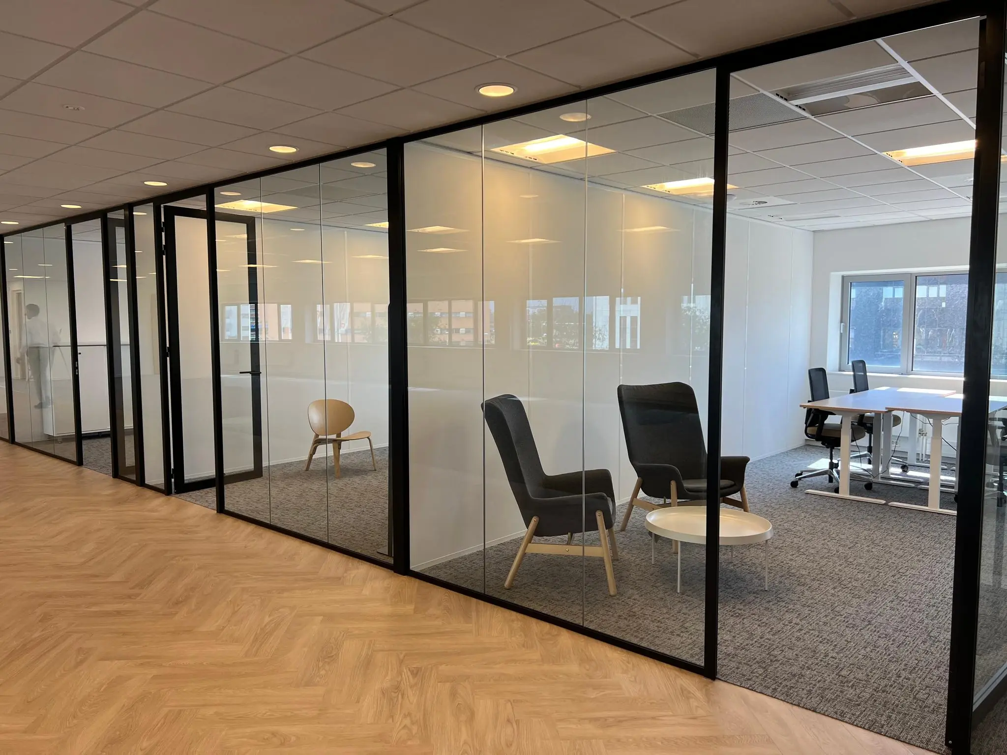 Moderne kantoorruimte in Rivium Quadrant met glazen vergaderruimtes en minimalistisch meubilair.